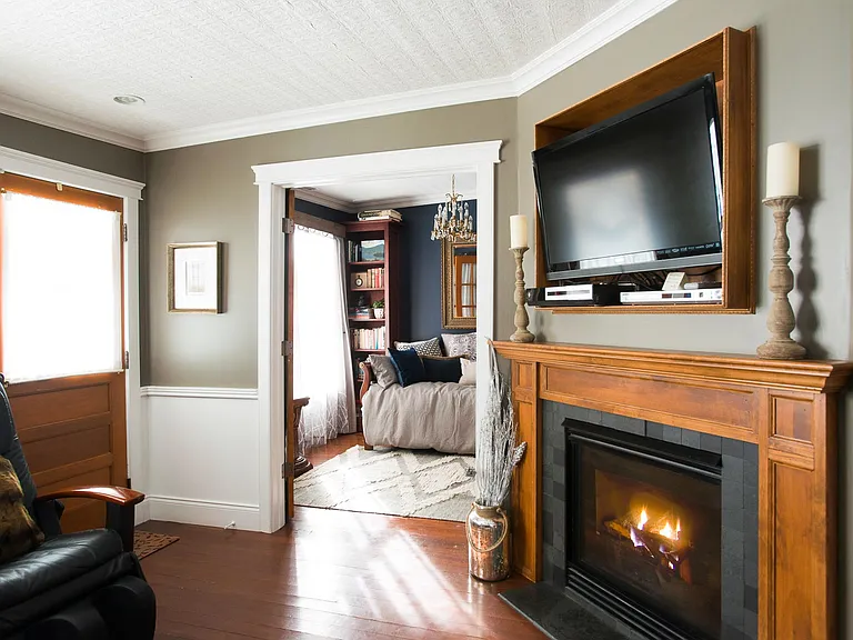 Living room fireplace with library in background.
