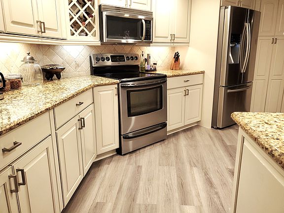 Large Granite Kitchen, wine rack stainless appliances all new luxury vinyl plank floors through-out condo