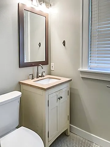 Bathroom has storage cabinets, a full-size washer and dryer, and large antique soaking tub.