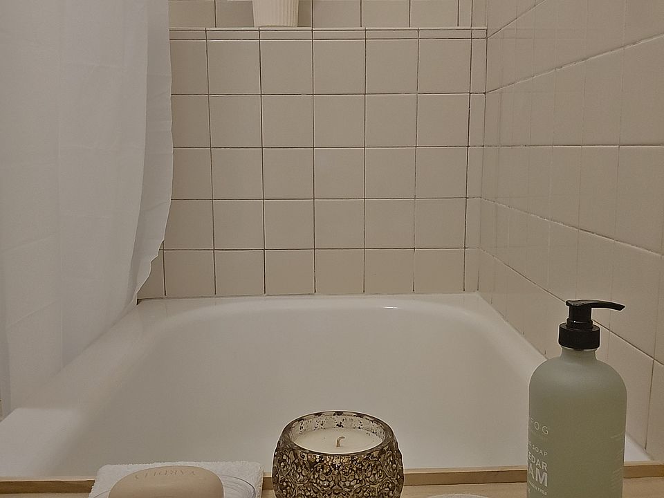 The tub/shower is large with built-in tile shelf.