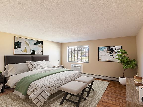 Large bedroom with wood flooring and ample natural light