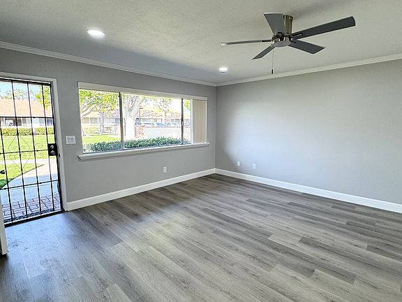 Living room, with vinyl plank flooring, new paint, ceiling fan and recessed lighting