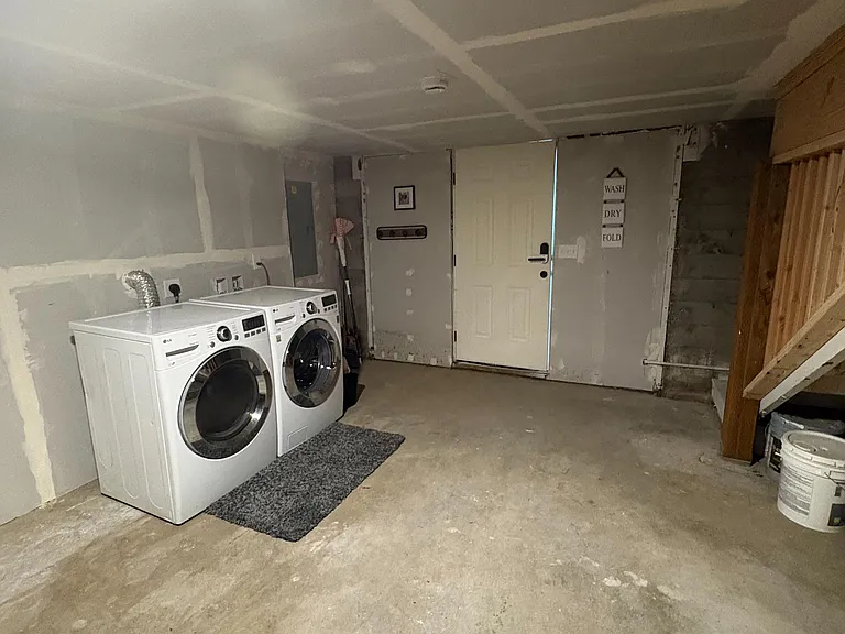 Dedicated laundry area with full-size washer and dryer and open floor space for sorting, folding, and storage.