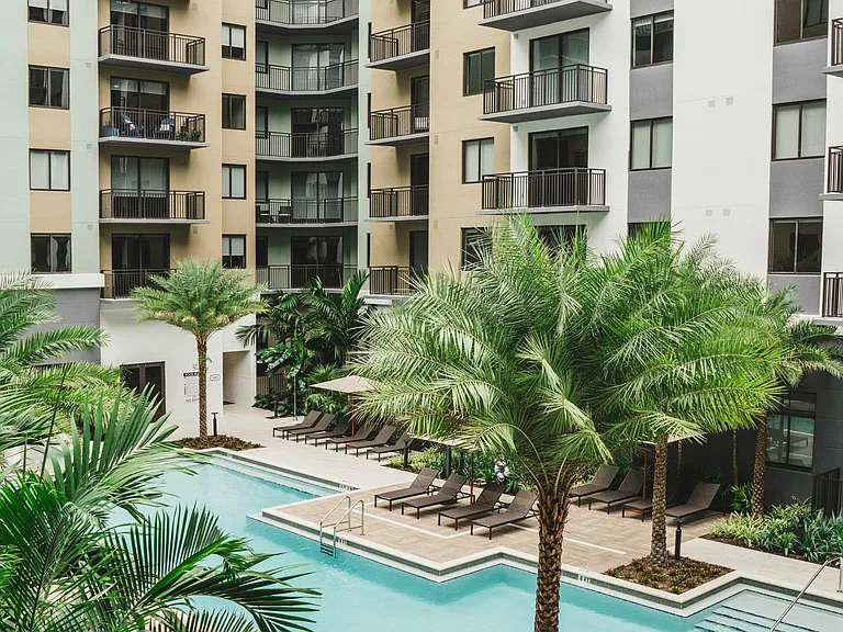 Available apartments feature balconies that offer breathtaking views of the shimmering pool below.
