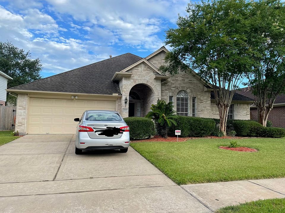 Very pleasant elevated front view with mature trees and finely manicured lawn.