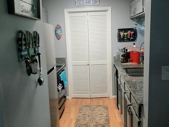 Kitchen with granite countertops. Laundry with washer/dryer at the end of kitchen.