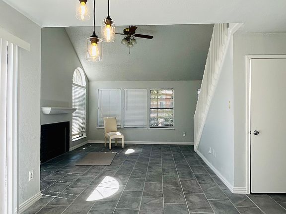 Spacious living room with soaring ceilings, sleek 1'x2' ceramic tile floors, and contemporary 3-light pendant fixture. The perfect blend of modern style and comfort for gatherings or quiet evenings at home!