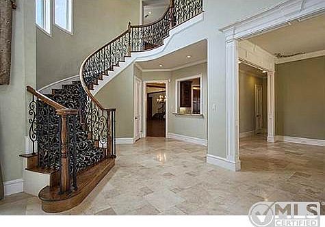 Foyer features a staircase with wrought iron balusters