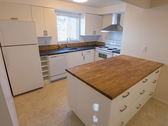 Kitchen looking from staircase into living room. Also visible is downstairs bathroom #2 w/ shower.