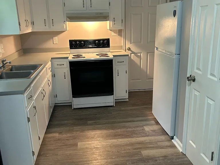 Totally electric kitchen with new refrigerator and pantry. Door leading to enclosed garage with washer and dryer