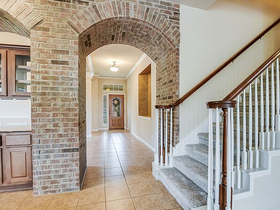 Statement archway welcomes you from the entryway and formal dining room to the kitchen and family room