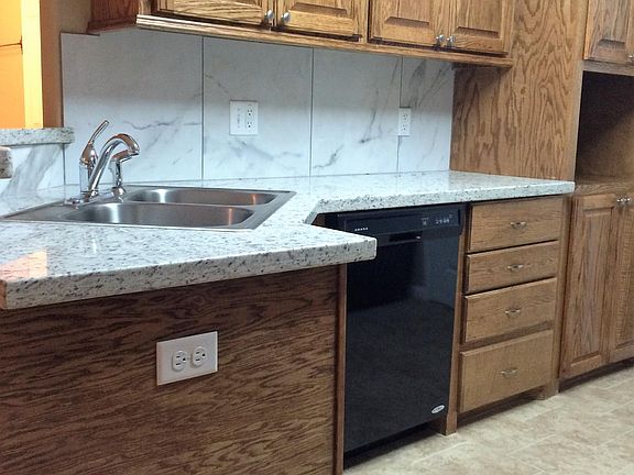 Kitchen with custom wood cabinets, dishwasher, porcelain bac