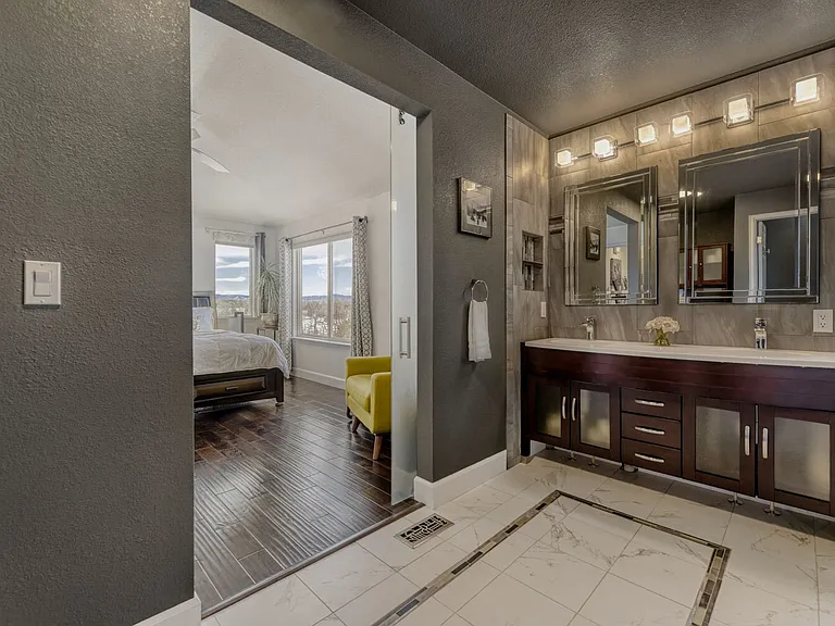 primary en suite bath with double sinks and glass sliding door