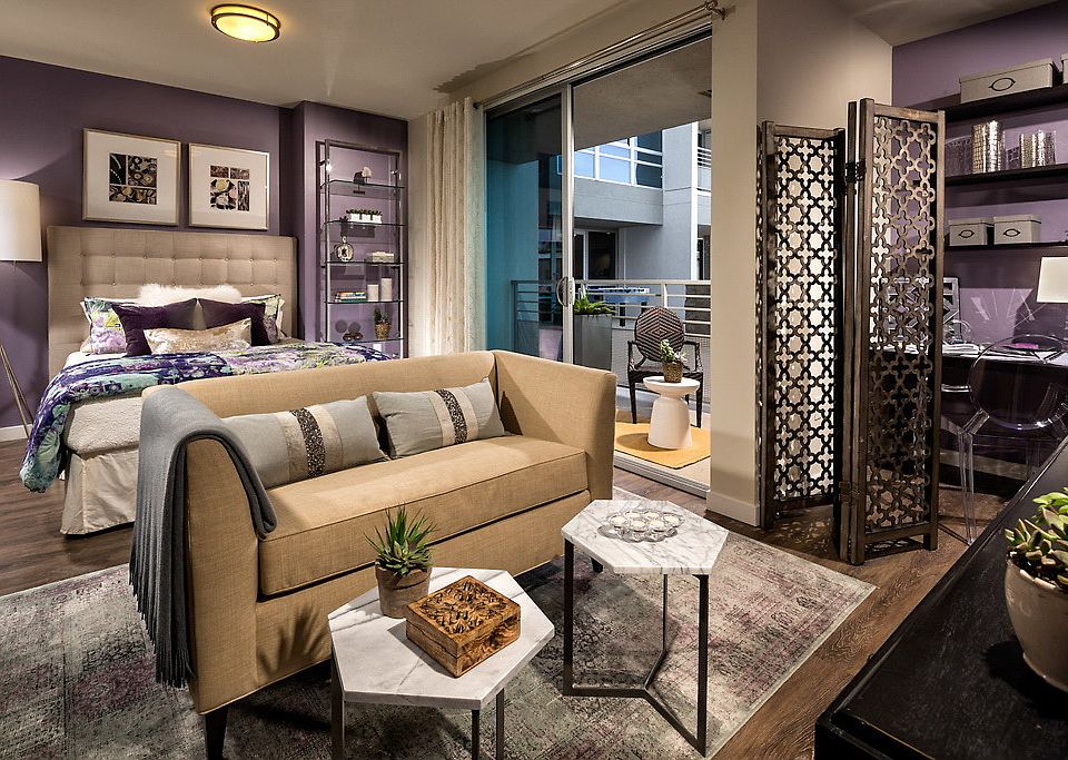 Staged bedroom with hardwood style vinyl flooring and sliding door to balcony.
