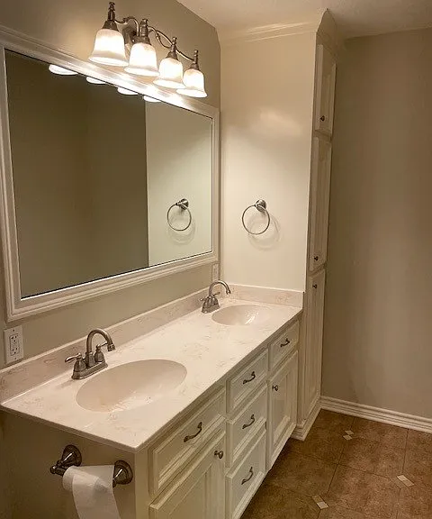Master bath with dual vanity and large linen cabinet.
