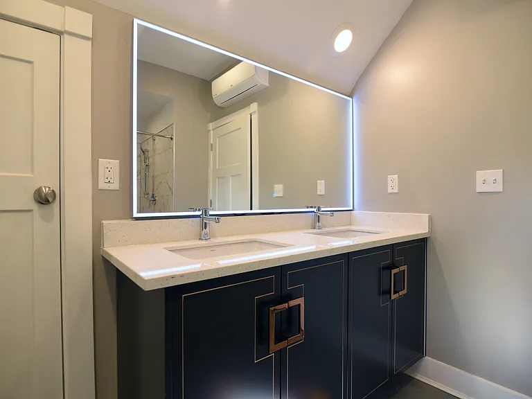 Uber Cool Owner's bathroom quartz countertops over unique floating cabinets.