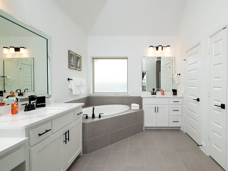 Primary bathroom has a garden tub, two sinks, and a walk-in shower