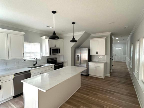 The home features a spacious kitchen, with updated appliances, a deep farmhouse style sink, quartz countertops, tons of light and cabinet space.