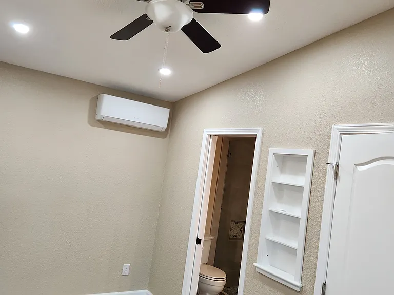 Master bedroom's fan/light, mini split, built-in shelf and entrance to bathroom.