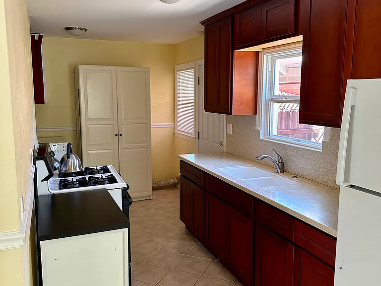 Kitchen. Newer cabinets, counter + sink.