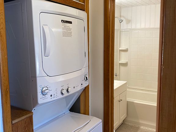 Washer and dryer on main level with shelves for storage.