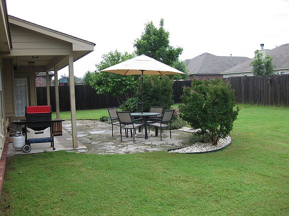 Covered patio with extended flagstone patio, professionally landscaped.