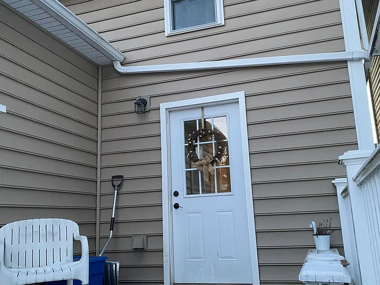 Entrance to 2nd floor apartment is in the rear of the building. Exterior stairs lead to small deck. Deck build with composite material (i.e. Trex), vinyl railing and handrail.