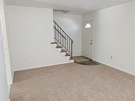 Living room view of front door and stairs