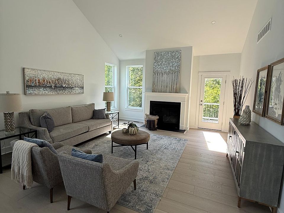 Living room with high ceiling and fire place. Note the private deck that opens up to the woods