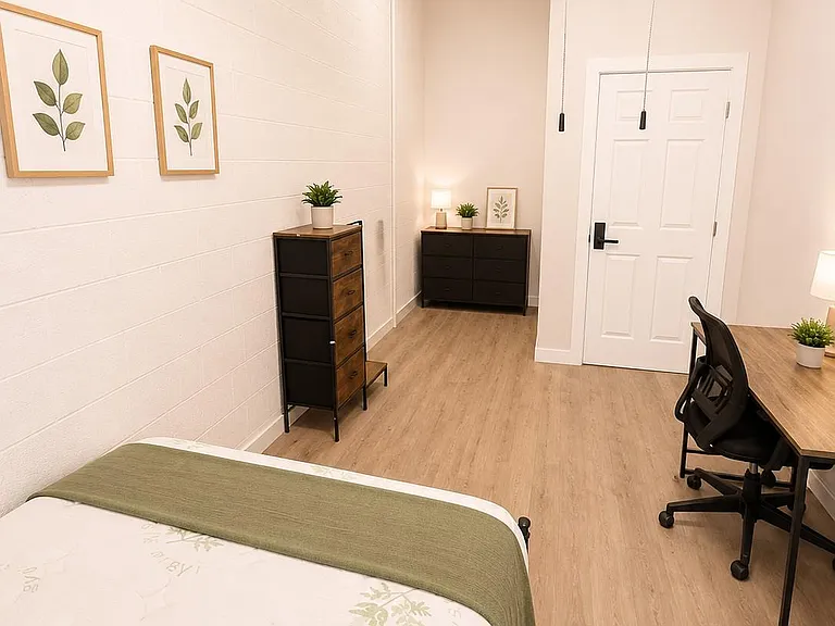Well-appointed bedroom with a dedicated desk workspace, ample floor space, and contemporary lighting and finishes.