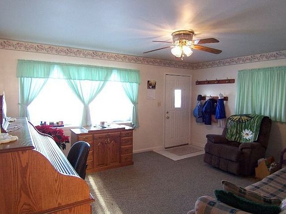 Large windows & ceiling fan enhance the living room