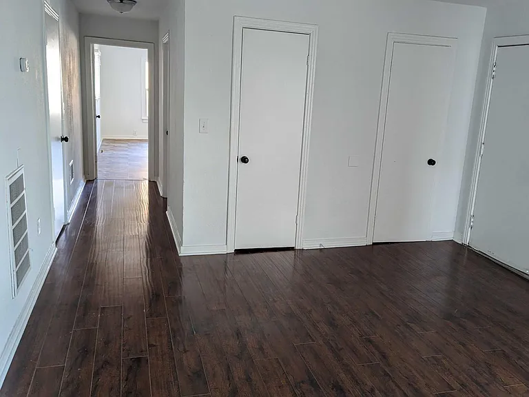 View from living room looking down the hallway which leads to the bathroom and spacious kitchen area. Unit has two separate closets for storage.