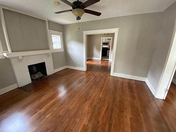 Den with hardwood floors.