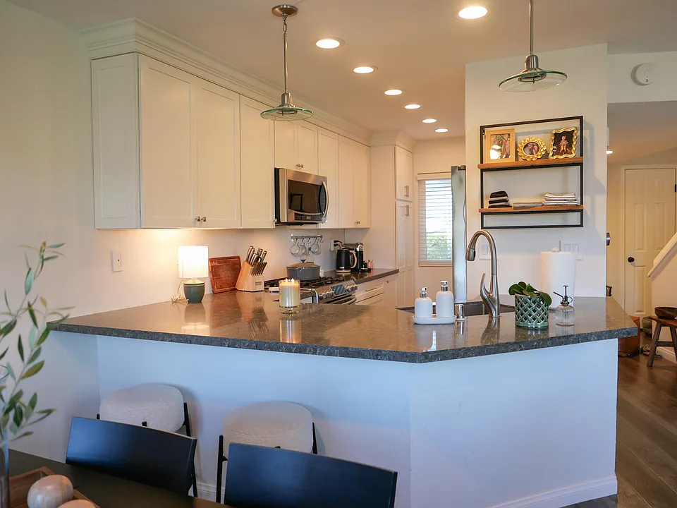 Remodeled kitchen open to living space with newer quartz countertops and bar seating