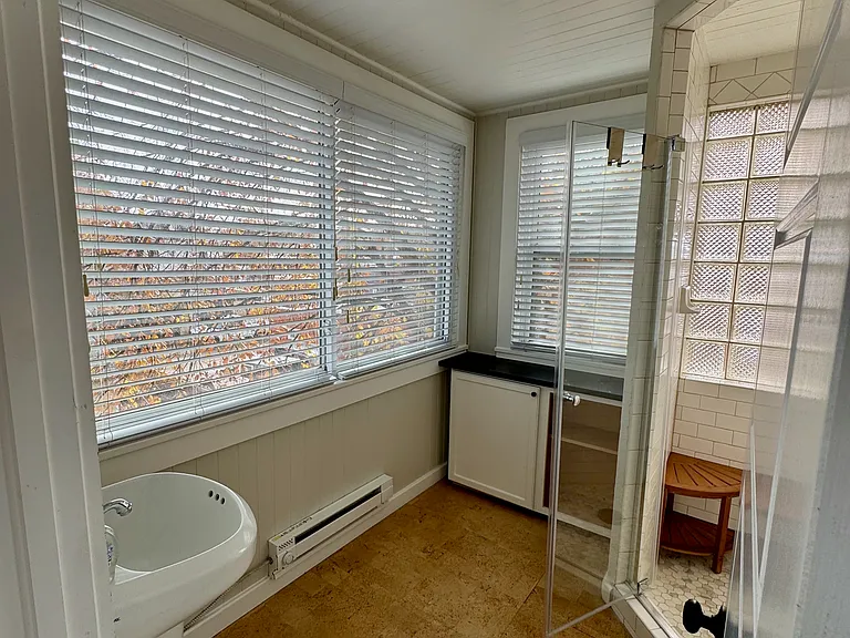 3/4 Bathroom with garden-like setting. Cork flooring and built in cabinetry