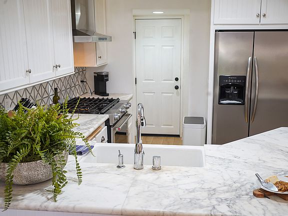 Open kitchen with premium appliances with garage entry.