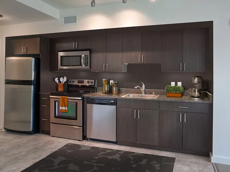 Classic Package I kitchen with brown speckled granite countertops, espresso cabinetry, stainless steel appliances, and hard surface flooring