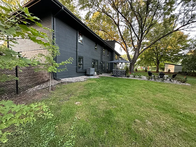 Sprawling backyard with sprinkler system.