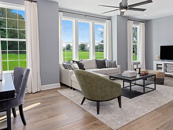 Living room with wall of windows in a DRB Homes Whitaker II model at the Rolling Hills community.