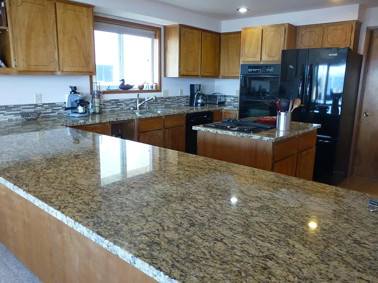 Fully appointed kitchen with granite counters, new LVP flooring, JennAire stove, self cleaning oven, microwave/convection oven and French-door fridge.
