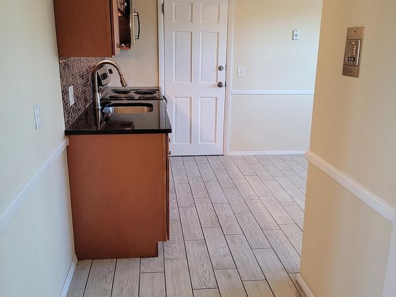 Looking into kitchen from bathroom hall. Rear exit from the apartment. Room for kitchen shelving or small pantry.