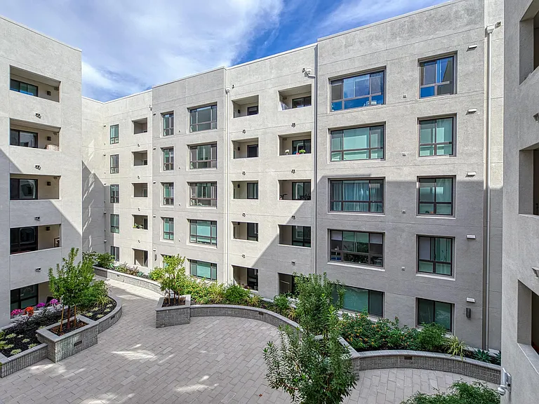 Courtyard with greenery and curved pathways offering fresh air, quiet moments, and room for lawn games.
