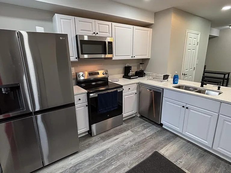 Updated kitchen with stainless-steel appliances, ample cabinet storage, and a large peninsula with double sink and dishwasher