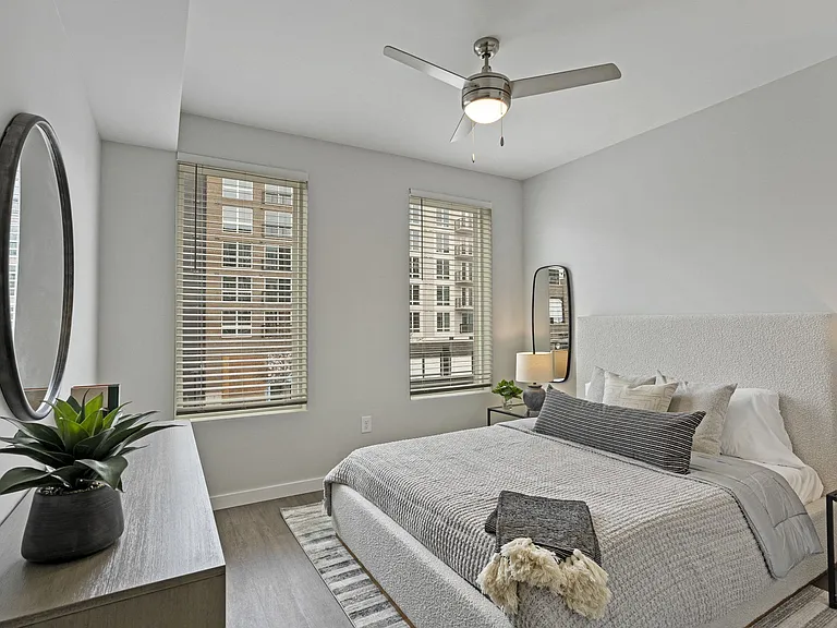 Spacious Bedroom With Ceiling Fan And Large Windows
