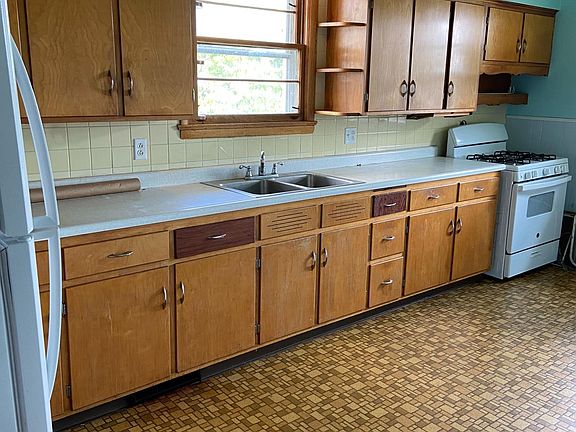 Large kitchen with oven and refrigerator.