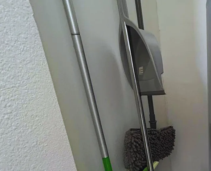 Cleaning essentials, including a broom, mop, and dustpan.