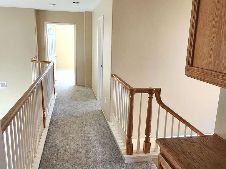Looking down the upstairs hall toward the 3rd bedroom and primary. Linen storage on the right.