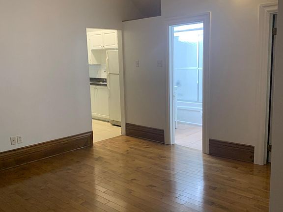 living room with view to bathroom (centre) and kitchenette (left)