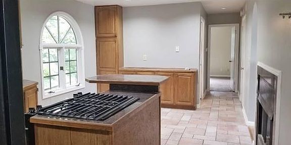 Kitchen with view of the dining area. Fireplace through from the family room. Down the hall is the basement stairs on the right, bathroom on the left and bonus room straight forward.