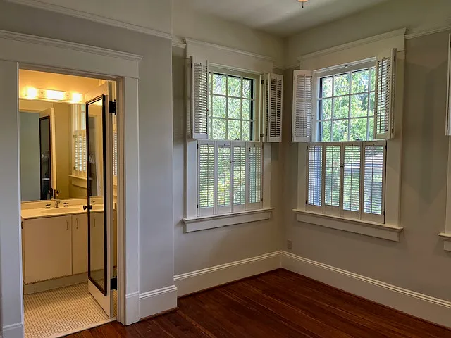 Bedroom with large windows; Bath entry to left